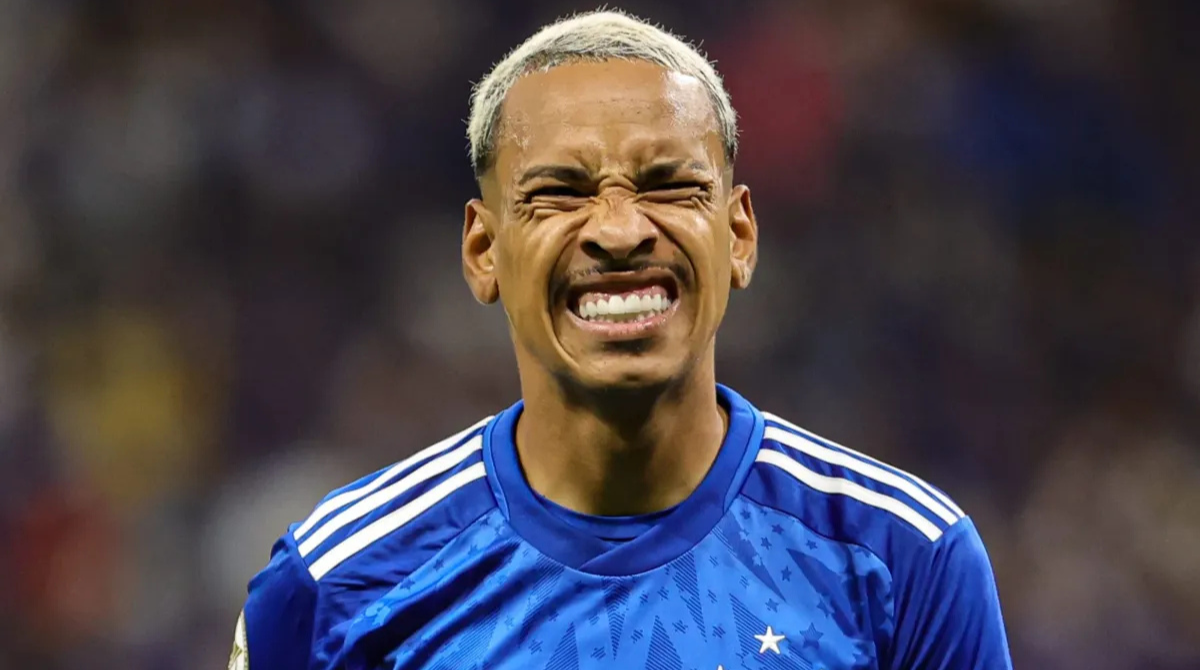 Matheus Pereira com a camisa do Cruzeiro com uma expressão facial de dor