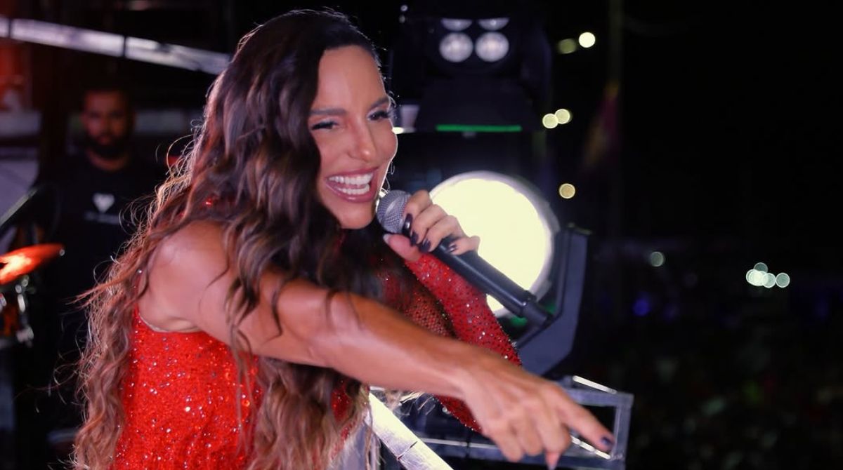 Ivete Sangalo cantando em trio elétrico usando roupa vermelha