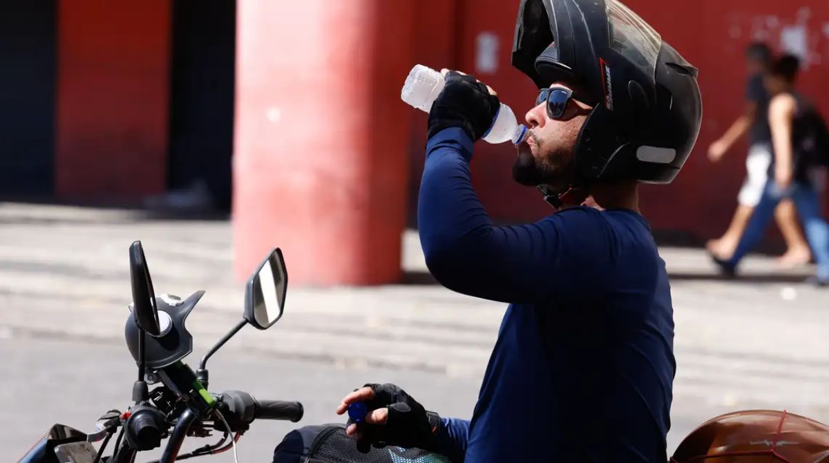 motoqueiro bebe água no calor