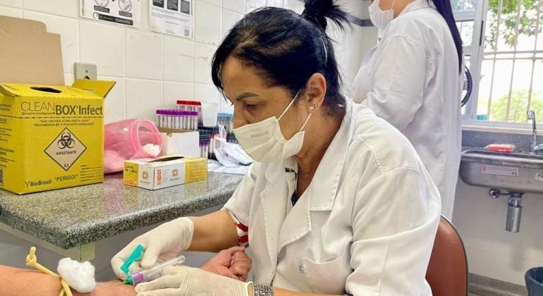 Enfermeira faz coleta de exame em morador