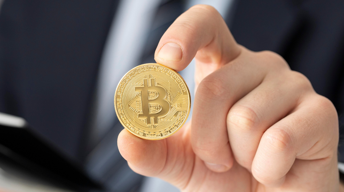 Mão com uma moeda de bitcoin