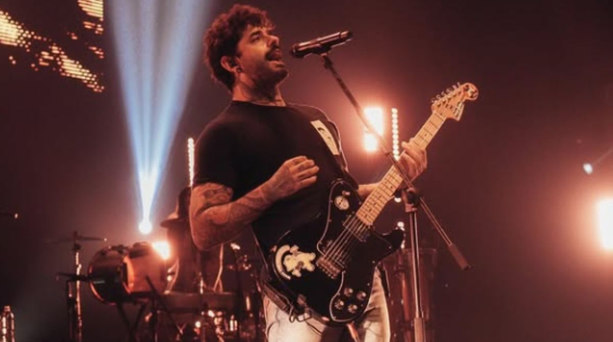 Lucas Silveira, da banda Fresno, tocando guitarra em show.