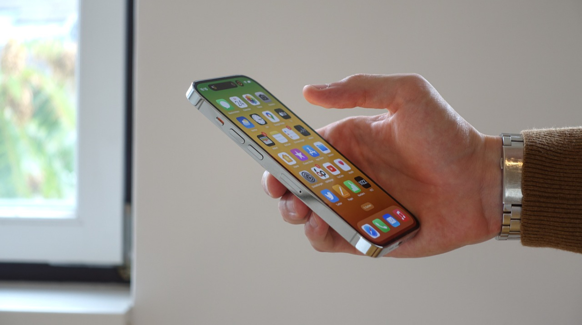 homem segurando iphone